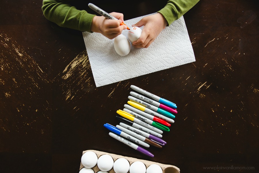 kid decorating eggs with sharpies