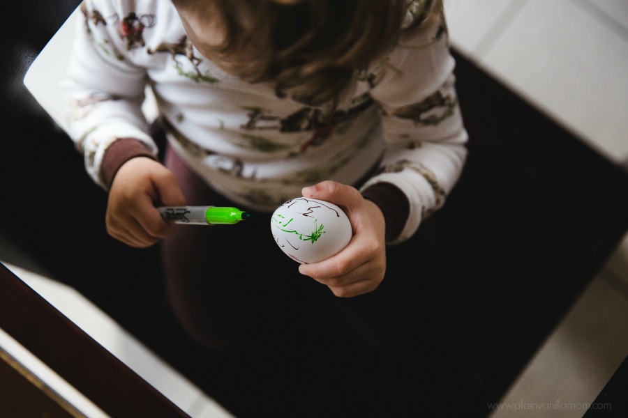 toddler decorating easter eggs with sharpie